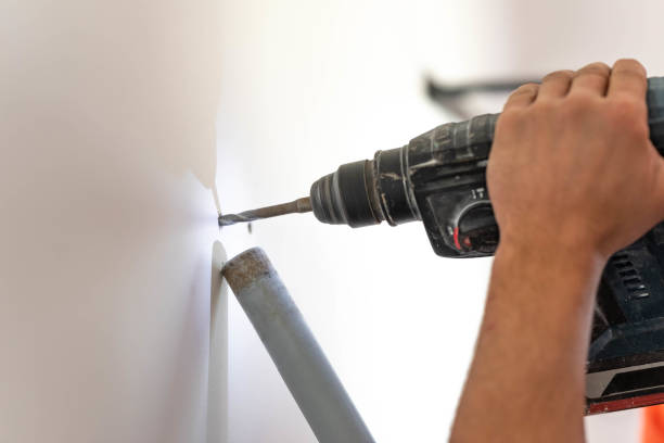 istock Man drilling a hole in the wall 1144621351