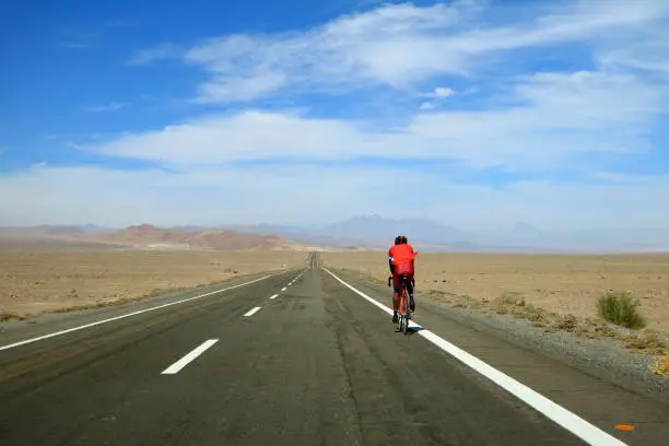 Man cycling on the highland road of Atacama desert, northern Chile, South America