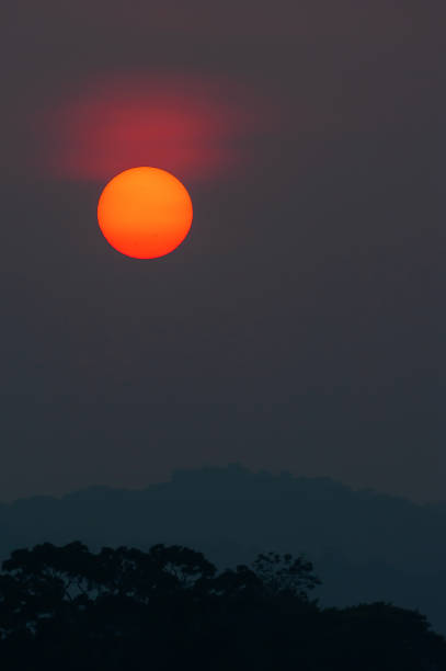 istock Fantastic the red sun setting above the deep jungle and mountain range. 1144622691