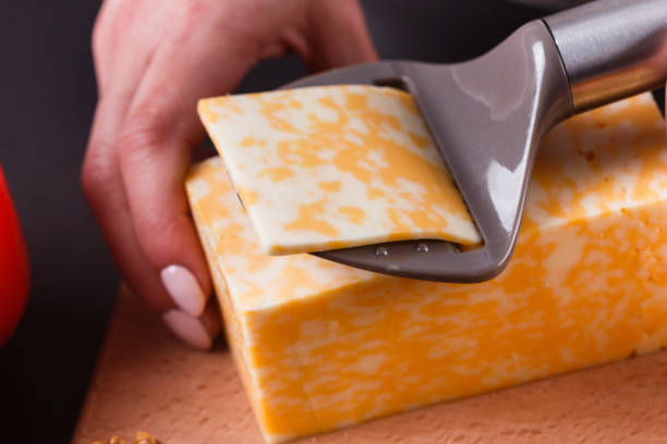 istock young woman slicing cheese in a gray apron 1144623193