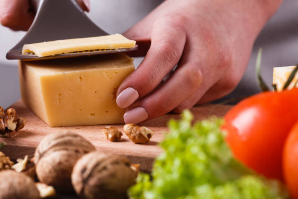 istock young woman slicing cheese in a gray apron 1144623294
