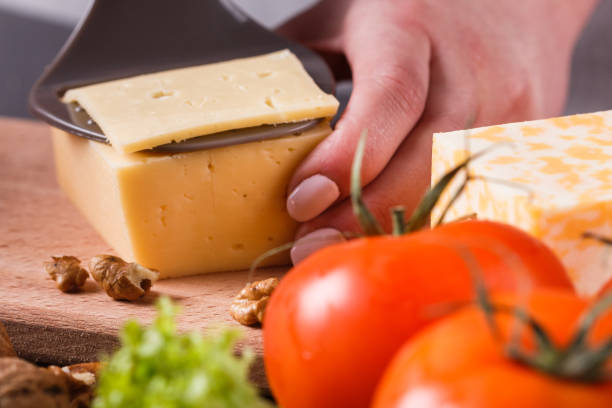 istock young woman slicing cheese in a gray apron 1144623373