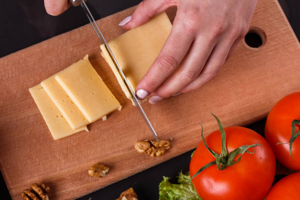 istock young woman slicing cheese in a gray apron 1144623432