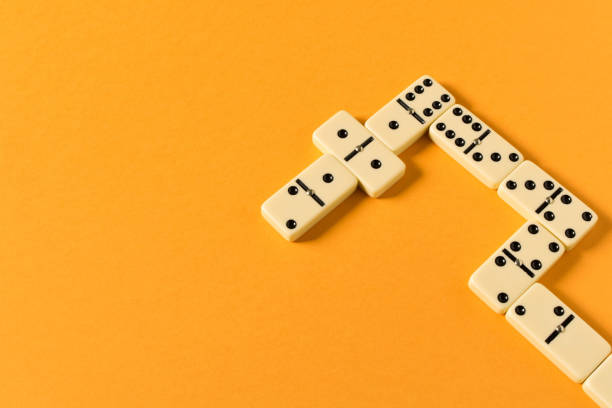 istock Playing dominoes on a orange table. Domino effect. 1144624522