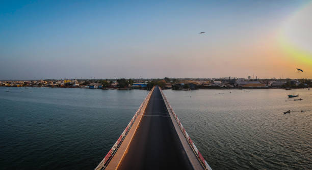 Road bridge over casamance river. Aerial view of the road bridge over casamance river in Ziguinchor, Senegal, Africa during a sunset. Drone picture looking towards the city above the driving platform. casamance river stock pictures, royalty-free photos & images