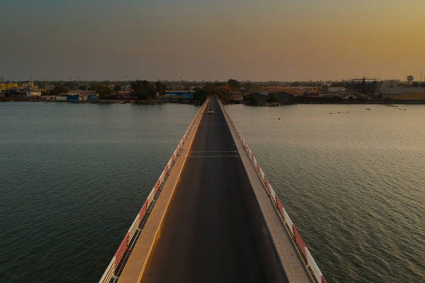 Road bridge over casamance river. Aerial view of the road bridge over casamance river in Ziguinchor, Senegal, Africa during a sunset. Looking towards the city above the driving platform with yellow taxi crossing the bridge. casamance photos stock pictures, royalty-free photos & images
