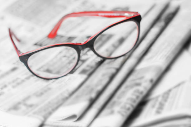 istock News concept, folded newspaper closeup, eyeglasses. 1144627950