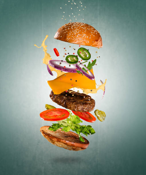 istock Tasty cheeseburger with flying ingredients on color pastel background 1144631145
