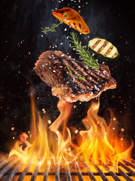 istock Tasty beef steaks flying above cast iron grate with fire flames. 1144631510