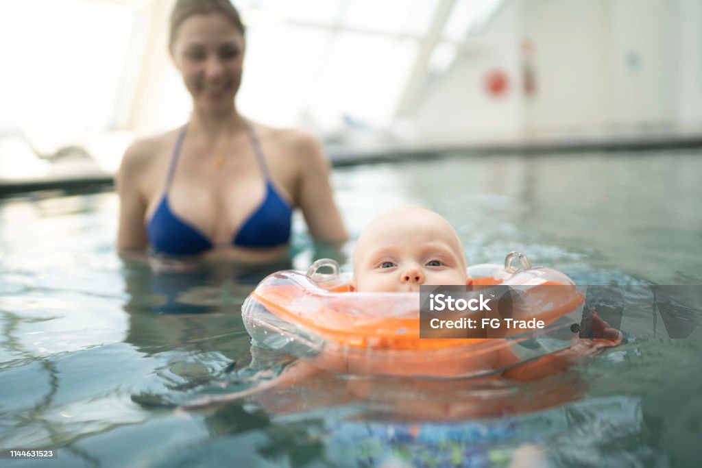 Mom with her baby son inside the pool Baby - Human Age Stock Photo