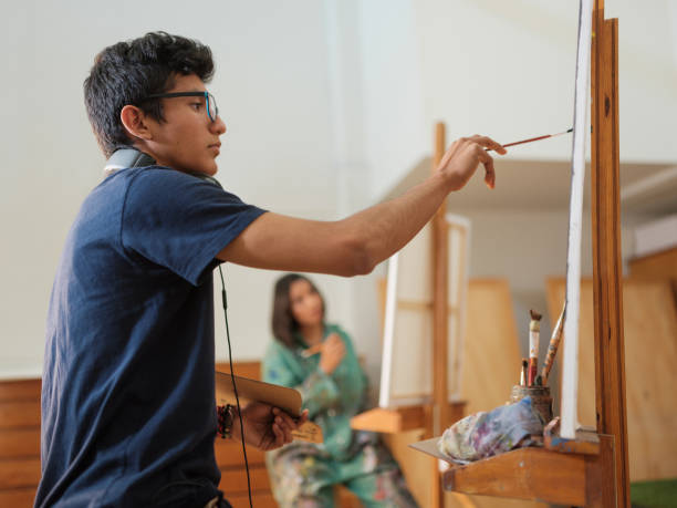 istock Concentrated student artist paints on a canvas 1144631605