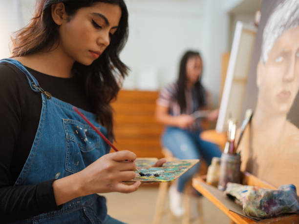 istock Concentrated female art student mixing colors on a palette 1144631625