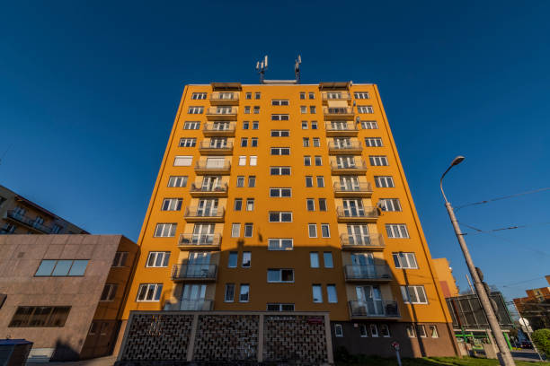 Yellow block of flats with blue sky in spring sunny evening Yellow block of flats with blue sky in spring sunny color evening cesky budejovice stock pictures, royalty-free photos & images