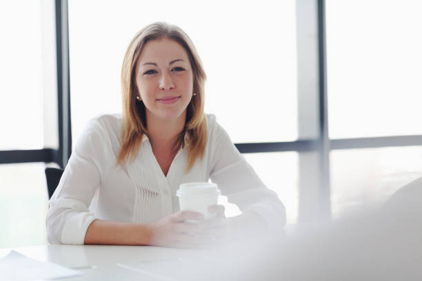 junge frau hört sprecherin in bürositzung - board room business conference table window stock-fotos und bilder