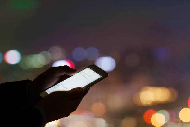 istock Hands holding smart phone in urban area at night 1144636573
