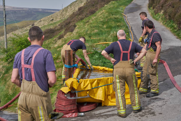 el equipo de bomberos que atiende incendios de pantano asegura el suministro de agua - uk fire department fire engine team fotografías e imágenes de stock