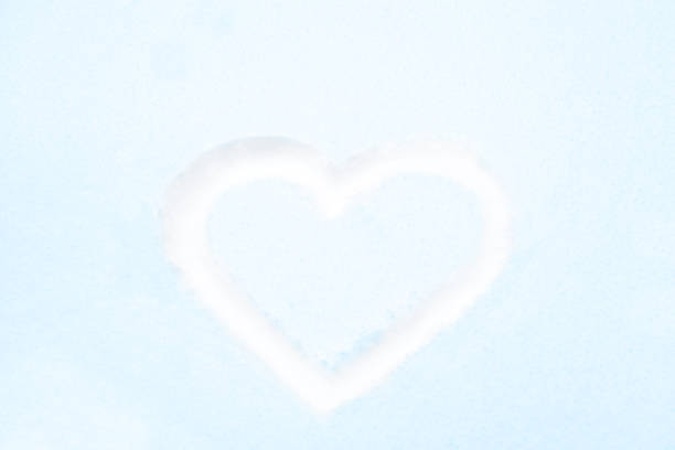 istock Blue heart shape drawing on white snow 1144638090