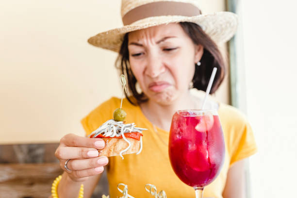 A woman tries Spanish cuisine for the first time and she is unhappy with the disgusting taste of delicacy A woman tries Spanish cuisine for the first time and she is unhappy with the disgusting taste of delicacy awful taste stock pictures, royalty-free photos & images