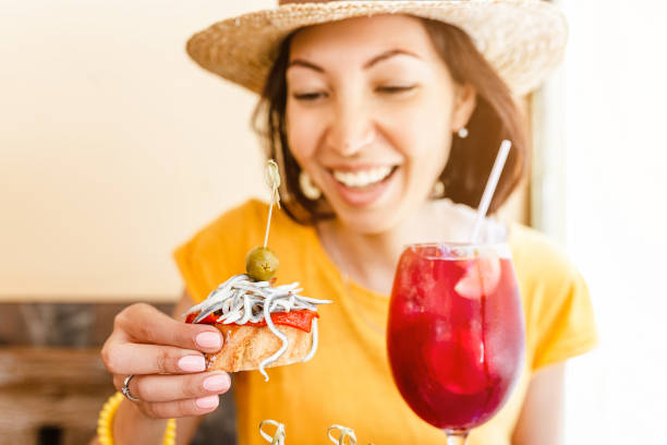 mujer joven disfrutando de deliciosas tapas tradicionales de aperitivos españoles, con copa de vino de sangría. concepto de viajes y alimentos en españa - home interior cocktail bar women fotografías e imágenes de stock