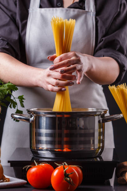 istock young woman in a gray apron preparing pasta 1144640781