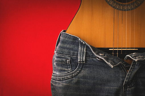 Photo of guitar making an allusion to the female body wearing jeans