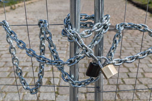 fence locked by steel chain with padlocks
