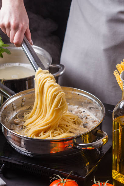 istock young woman in a gray apron preparing pasta 1144642685