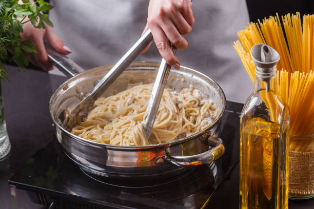 istock young woman in a gray apron preparing pasta 1144642691