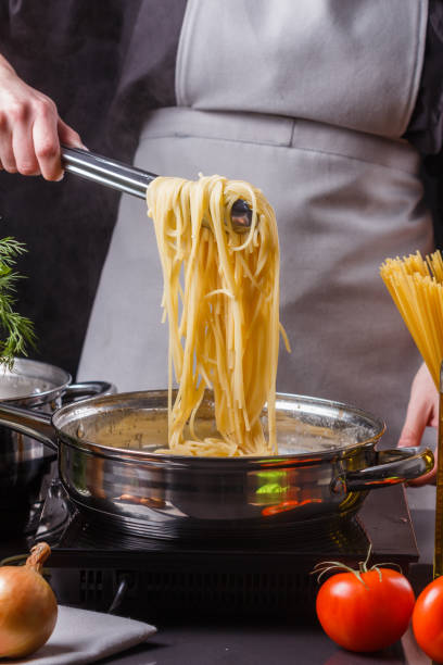 istock young woman in a gray apron preparing pasta 1144642701