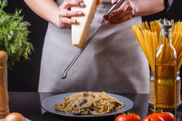 istock young woman in a gray apron preparing pasta 1144642733