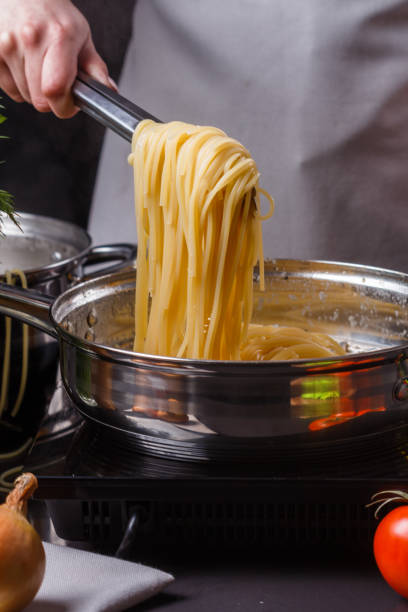 istock young woman in a gray apron preparing pasta 1144642742