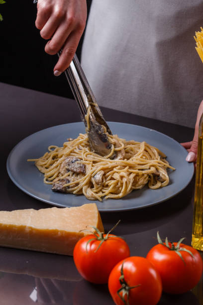 istock young woman in a gray apron preparing pasta 1144642793