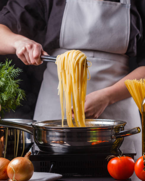 istock young woman in a gray apron preparing pasta 1144642843