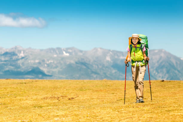 Happy woman walking with backpack in Pyrenees mountains Highlands