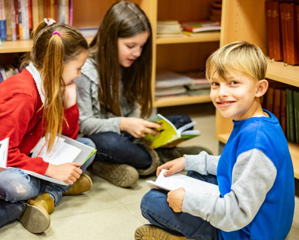 istock Portrait cute boy in a school library 1144645241