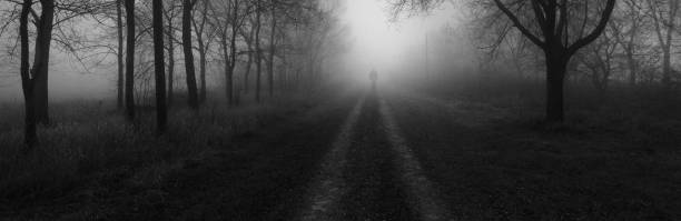 Silhouette of the man walking down the road