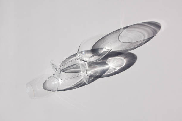 istock Two wine glasses lying on the table. Abstract shadows, sunlight, top view. 1144645915