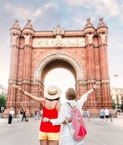 Traveler woman friends looking at the amazing architecture of the Arc de Triomf gate in Barcelona, Traveler woman friends looking at the amazing architecture of the Arc de Triomf gate in Barcelona, arc de triomf barcelona stock pictures, royalty-free photos & images