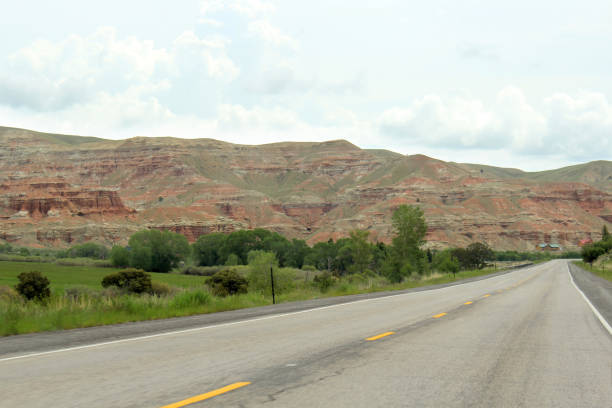 Driving on Highway through Wyoming red rock badlands, USA stock photo