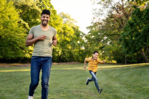 istock Father and son running and chasing each other in park 1144649535