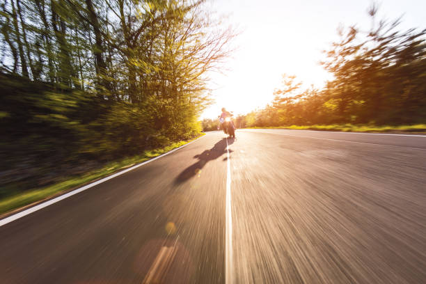 Motorcycle driver riding in European road. Outdoor photography, countryside landscape. Travel and sport photography. Speed and freedom concept