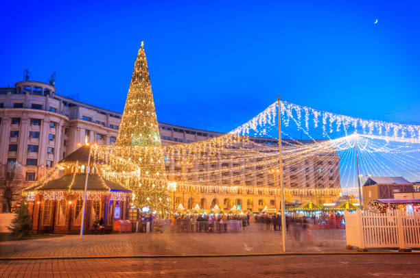 Christmas scene outdoor in Bucharest capital Decorated Christmas tree and lights around the market in Revolution Square in wintertime, Bucharest city of Romania bucharest photos stock pictures, royalty-free photos & images
