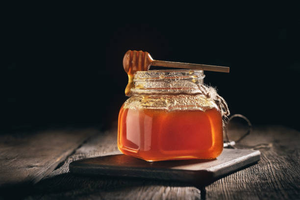 istock Jar of lavender honey on black background 1144653824