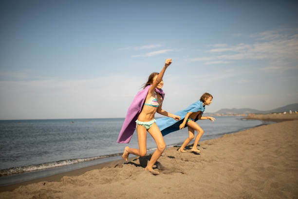 Group of young men and women walking down a beach.