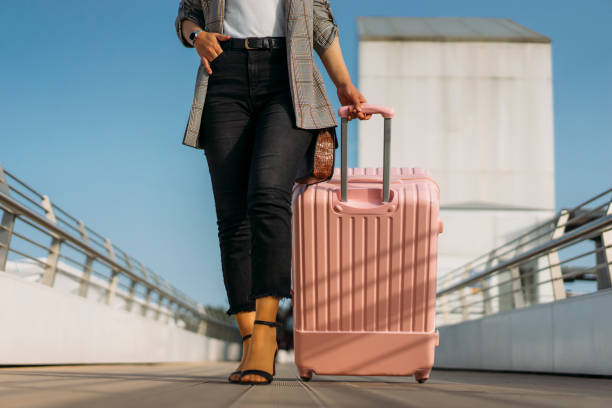 istock Woman walking with suitcase at airport terminal 1144655413