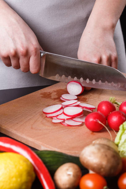 istock young woman in a gray apron cuts a radish 1144656896