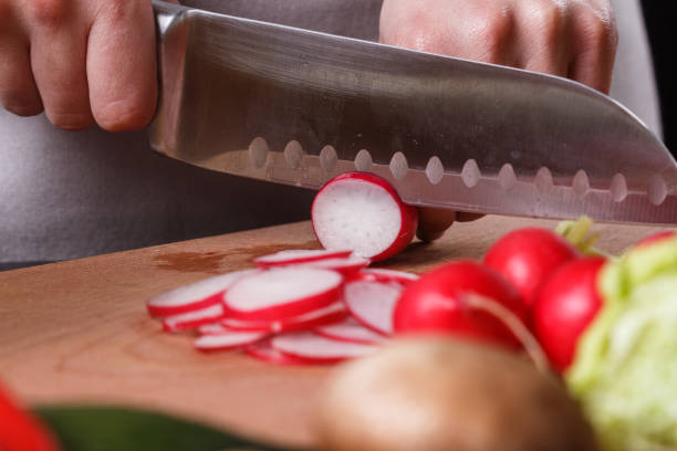 istock young woman in a gray apron cuts a radish 1144656926