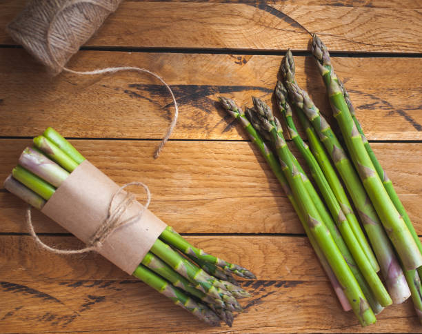 istock Fresh green asparagus on wooden background, top view 1144658131