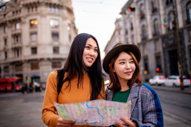 istock Two smiling Asian girls holding a map. 1144658351