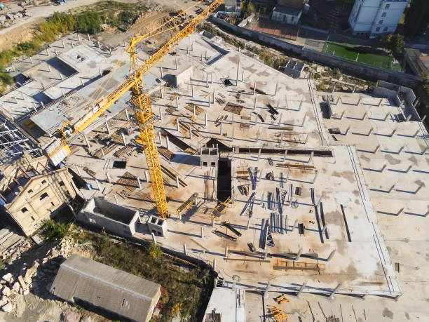 istock Construction site aerial view. Mall building base with solid concrete pillars. Heavy machinery and high tower crane working. Industrial aerial background 1144660658